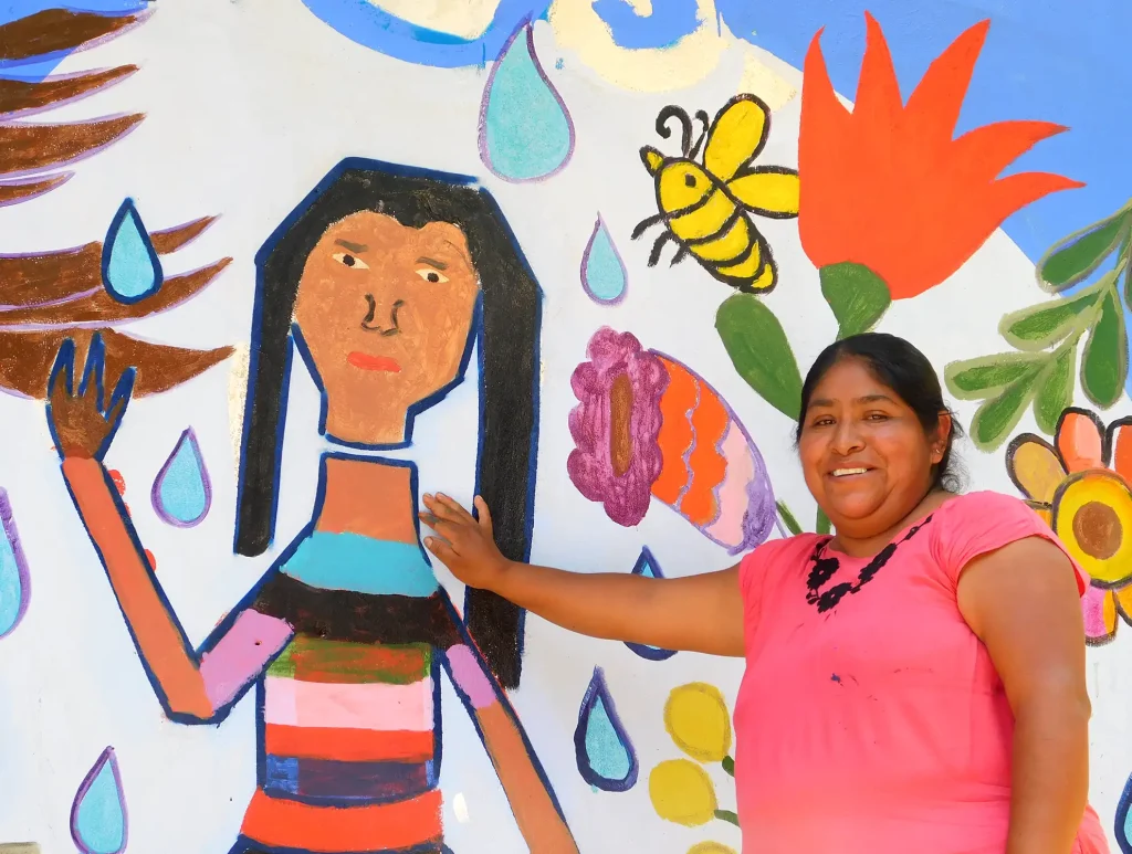 Rosalina in front of the mural she just finished painting with other people from the Teocuatlán community, San José Tenango, in Oaxaca, Mexico.