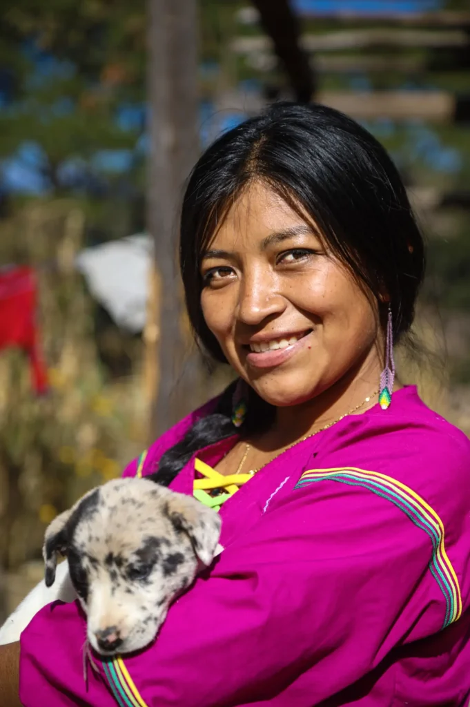 Ha Ta Tukari. Woman from the community posing with a puppy for the picture. Photo by Patricio Orden.