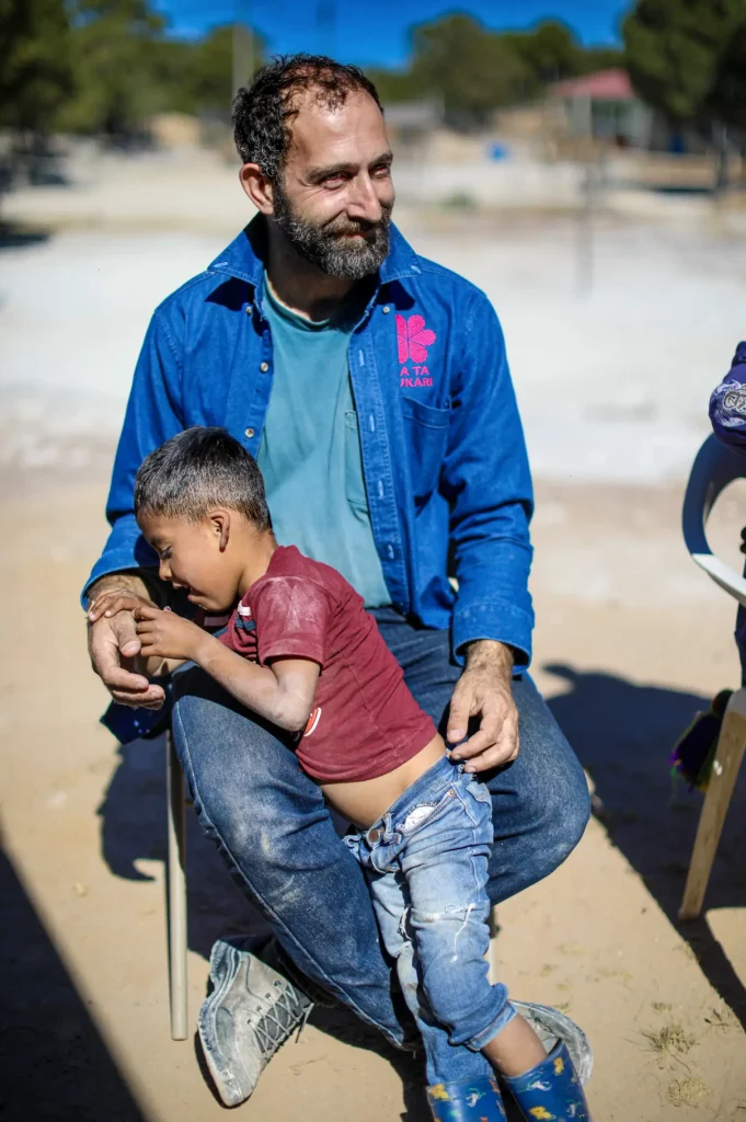 Ha Ta Tukari. Enrique Lomnitz playing with a kid in the community. Photo by Patricio Orden.